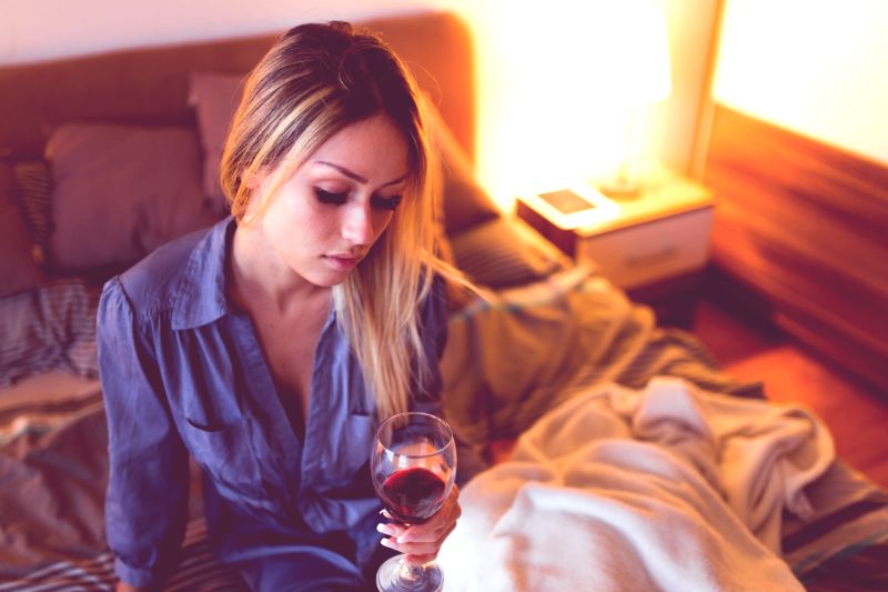 Девушка на кровати с вином