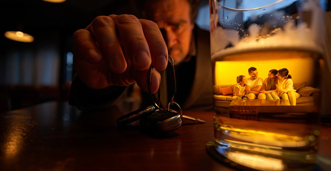 Водитель смотрит на бокал с алкоголем